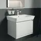 Waschbecken mit integrierter Ablagefläche und Unterschrank in Weiß, montiert an einer hellen Wand. Ideal Standard ist im Design erkennbar.